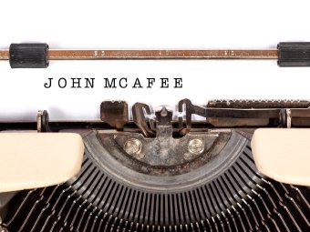 Grafika przedstawiająca maszynę do pisania z kartką, na której umieszczono napis John McAfee