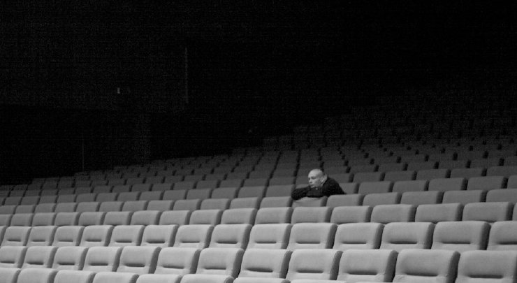 Okładka podcastu random:self - fotografia widza w pustej sali kinowej