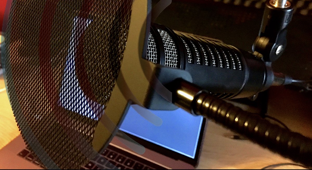 Okładka podcastu random:view - fotografia mikrofonu dynamicznego na tle ekranu LCD